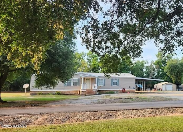 manufactured / mobile home with an outdoor structure and concrete driveway