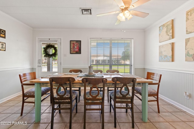 492 Kent St, Breaux Bridge, LA 70517 - dining space with healthy amount of natural light, light tile patterned floors, a wainscoted wall, ornamental molding, and ceiling fan