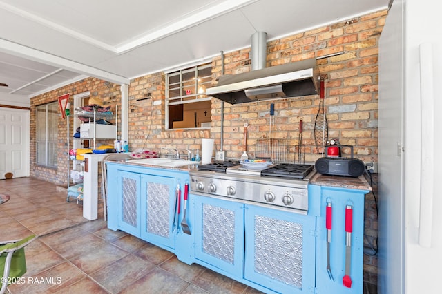 492 Kent St, Breaux Bridge, LA 70517 - kitchen featuring extractor fan, brick wall, tile patterned flooring, stainless steel gas stovetop, and a sink