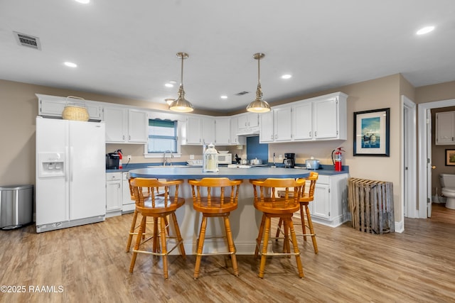 4998 Airhart Rd Unit A, Lake Charles, LA 70605 - kitchen featuring visible vents, light wood-style flooring, white cabinets, and white refrigerator with ice dispenser