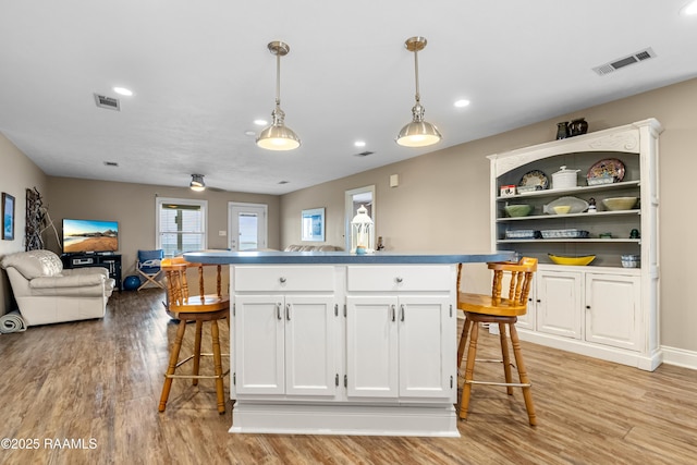 4998 Airhart Rd Unit A, Lake Charles, LA 70605 - kitchen with open shelves, a breakfast bar area, open floor plan, light wood-type flooring, and visible vents