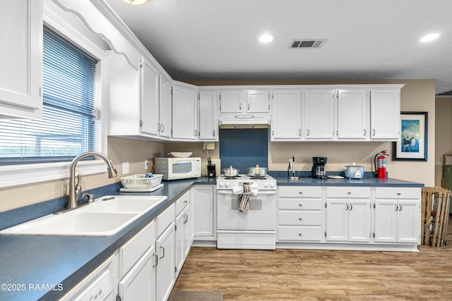4998 Airhart Rd Unit A, Lake Charles, LA 70605 - kitchen with visible vents, a sink, white cabinets, under cabinet range hood, and white appliances