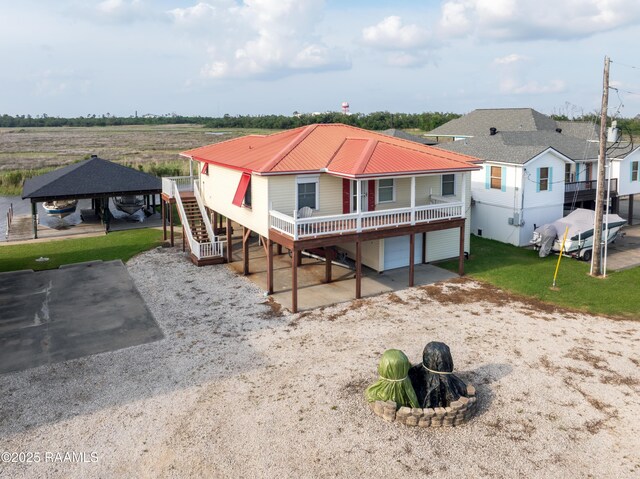 4998 Airhart Rd Unit A, Lake Charles, LA 70605 - rear view of property with driveway, metal roof, a wooden deck, a garage, and stairs