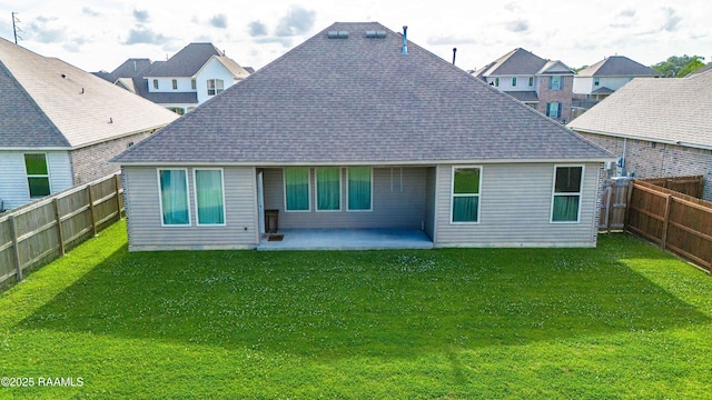 rear view of property featuring roof with shingles, a patio, a yard, and a fenced backyard