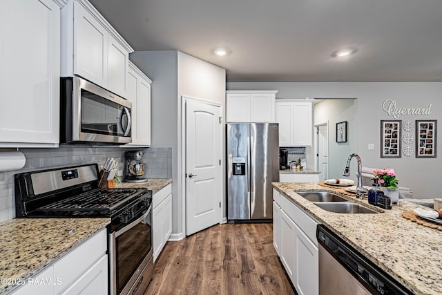 kitchen featuring a sink, appliances with stainless steel finishes, white cabinetry, and dark wood-type flooring