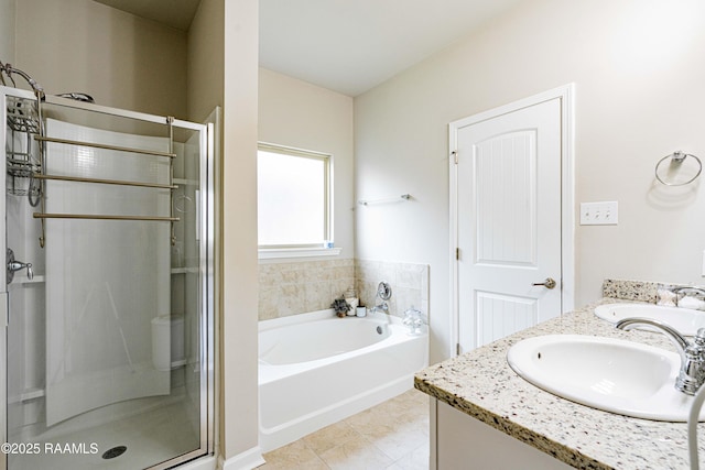 full bath featuring a sink, double vanity, a shower stall, and a bath