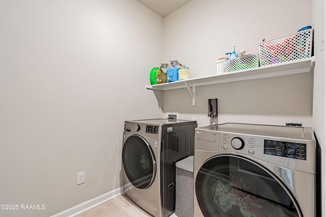 clothes washing area featuring laundry area, baseboards, and separate washer and dryer