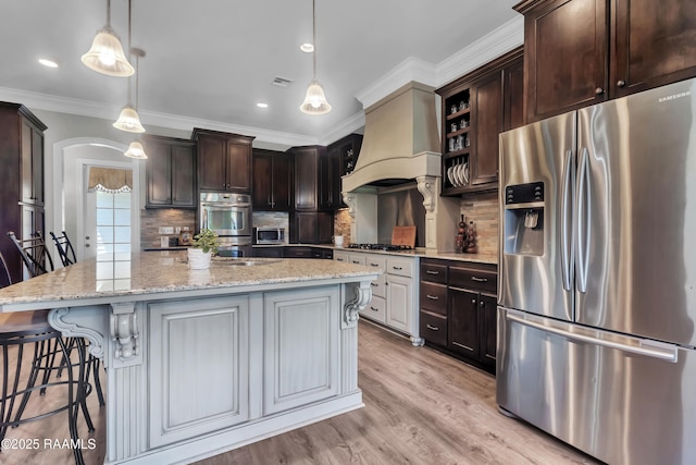 kitchen featuring dark brown cabinetry, visible vents, tasteful backsplash, custom exhaust hood, and stainless steel appliances