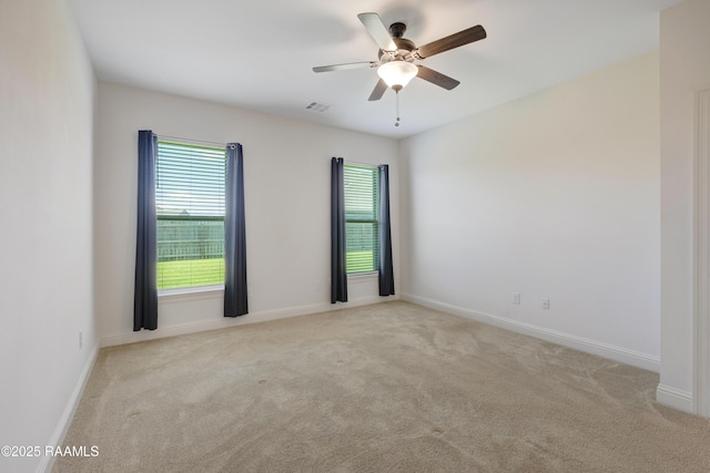 empty room with carpet floors, ceiling fan, and a wealth of natural light