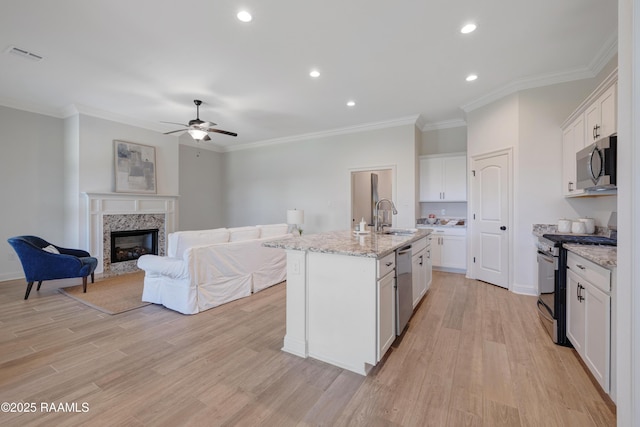 kitchen featuring visible vents, a ceiling fan, white cabinetry, a sink, and appliances with stainless steel finishes