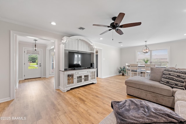 living room featuring ornamental molding, light wood-style floors, visible vents, and a healthy amount of sunlight