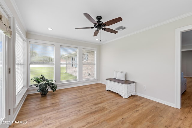 interior space with light wood-style floors, visible vents, a ceiling fan, and ornamental molding