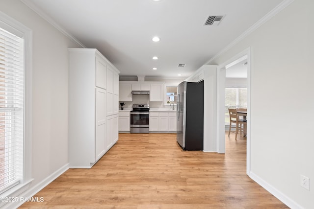 kitchen featuring light wood-style flooring, stainless steel appliances, crown molding, white cabinetry, and visible vents