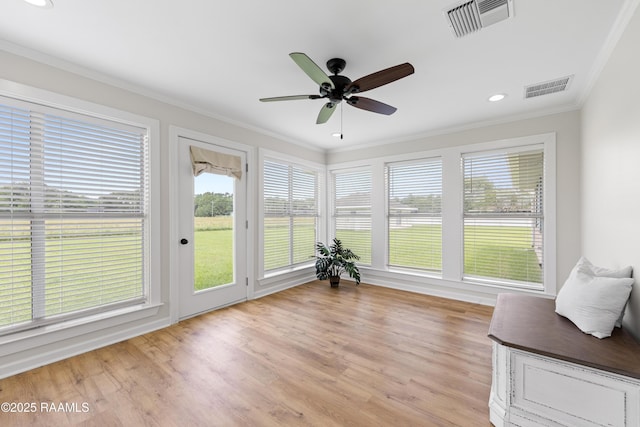 sunroom / solarium with a wealth of natural light, visible vents, and ornamental molding