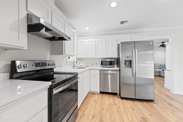 kitchen with a sink, extractor fan, stainless steel appliances, white cabinetry, and light countertops