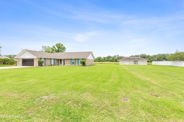 ranch-style house featuring a garage, fence, a front lawn, brick siding, and driveway
