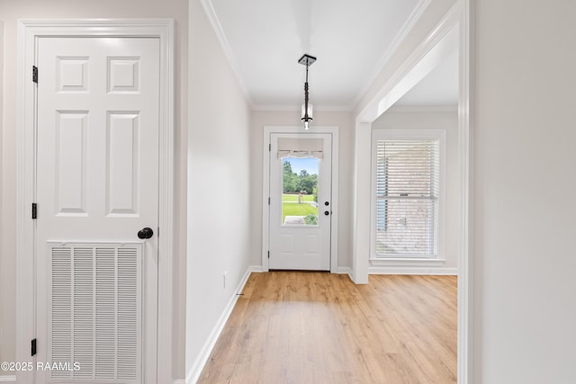 doorway to outside with crown molding, baseboards, light wood-type flooring, and visible vents