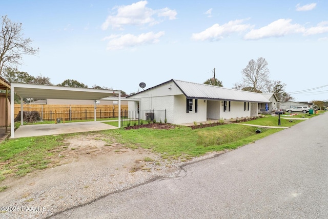 109 W Roosevelt St, Broussard, LA 70518 - view of front of home with dirt driveway, brick siding, and a detached carport