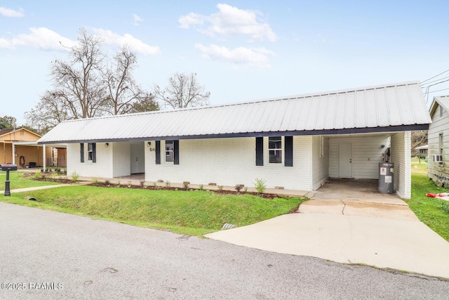 109 W Roosevelt St, Broussard, LA 70518 - view of front of house with brick siding, water heater, driveway, metal roof, and a carport