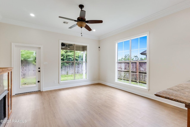 unfurnished living room with visible vents, ornamental molding, baseboards, light wood-type flooring, and a ceiling fan