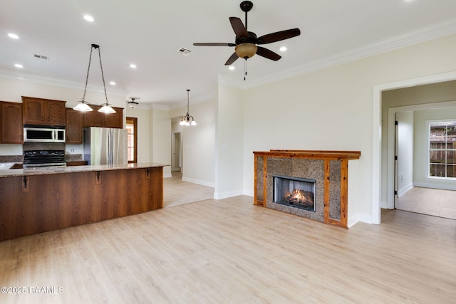 kitchen featuring a breakfast bar area, stainless steel appliances, light wood-type flooring, and visible vents