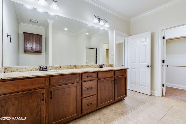 bathroom featuring tile patterned flooring, a sink, crown molding, and a stall shower