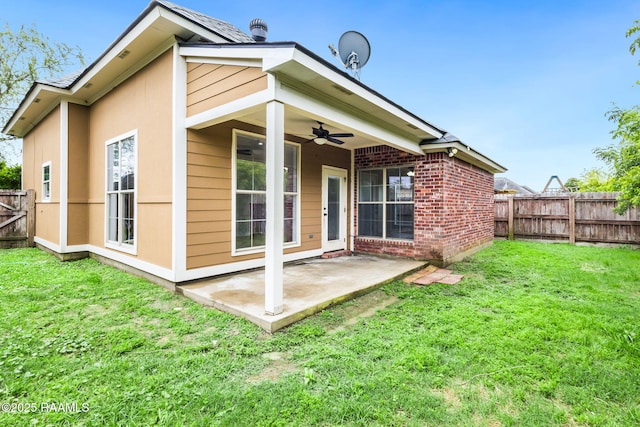 rear view of property with a lawn, a ceiling fan, a fenced backyard, and a patio area