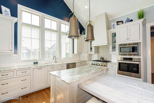104 Peaceful Hollow Ln, Lafayette, LA 70508 - kitchen featuring appliances with stainless steel finishes, vaulted ceiling, wood finished floors, a sink, and custom range hood