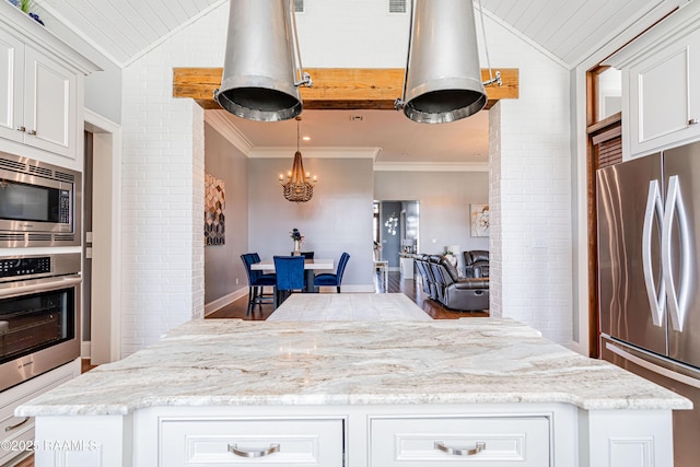 104 Peaceful Hollow Ln, Lafayette, LA 70508 - kitchen featuring a kitchen island, white cabinetry, appliances with stainless steel finishes, and vaulted ceiling