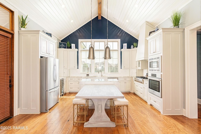 104 Peaceful Hollow Ln, Lafayette, LA 70508 - kitchen featuring light countertops, lofted ceiling with beams, light wood-style flooring, decorative light fixtures, and stainless steel appliances