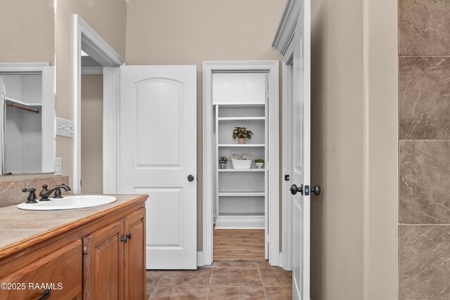 1115 Jules Broussard Rd, Breaux Bridge, LA 70517 - bathroom featuring vanity, tile patterned flooring, and a walk in closet