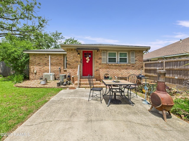 exterior space with central AC, fence, a patio, brick siding, and entry steps