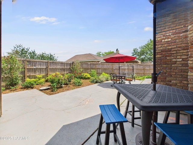 view of patio with a fenced backyard and outdoor dining area