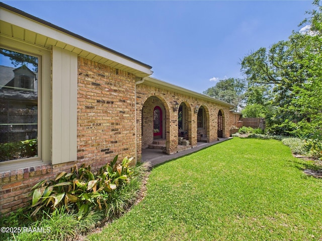exterior space with a lawn and brick siding