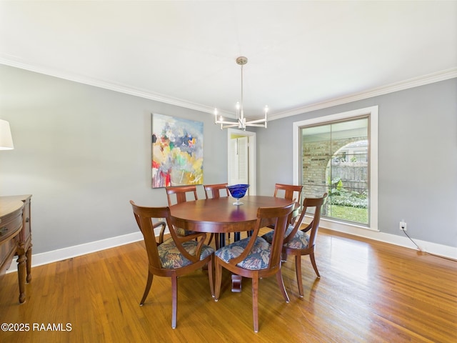 dining room with crown molding, baseboards, wood finished floors, and a chandelier