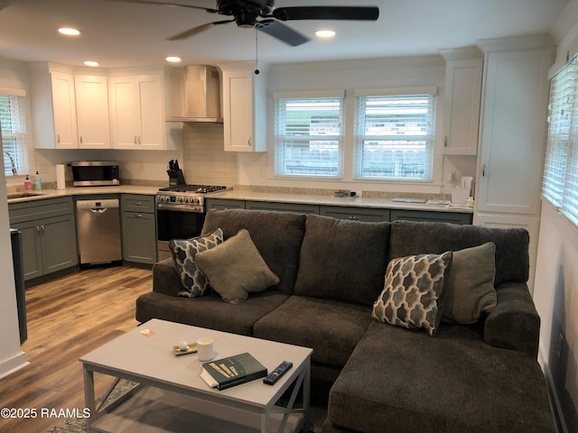 living room with a healthy amount of sunlight, light wood-style floors, a ceiling fan, and recessed lighting