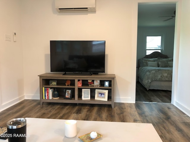 room details featuring ceiling fan, baseboards, a wall mounted AC, and wood finished floors