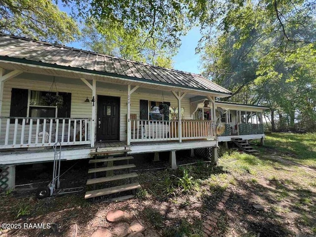 exterior space with covered porch, metal roof, and stairway
