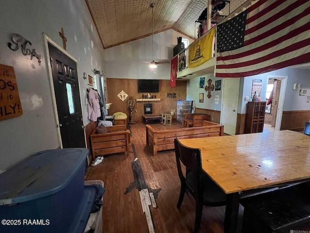 dining area featuring wainscoting, wood finished floors, and lofted ceiling