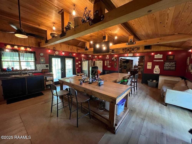 dining room with french doors, wood ceiling, beam ceiling, and hardwood / wood-style floors
