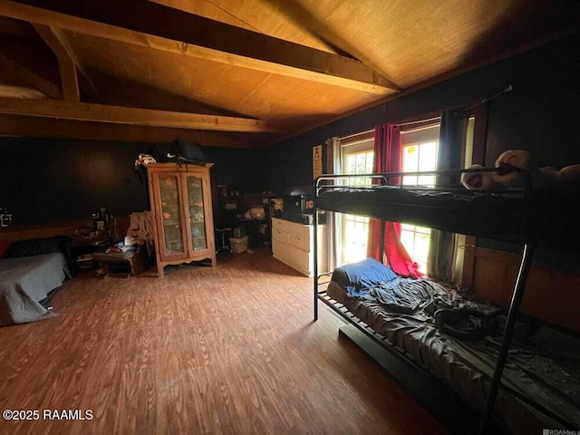 bedroom featuring lofted ceiling with beams and wood finished floors