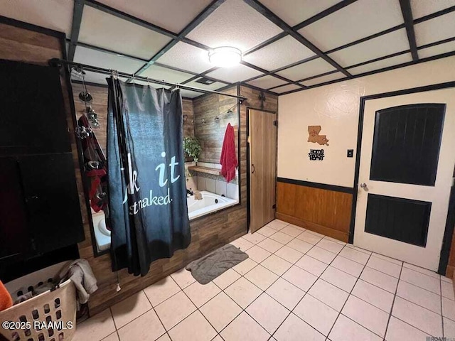 interior space featuring wooden walls, wainscoting, and tile patterned flooring