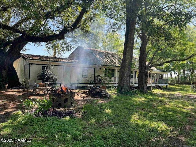 rear view of house featuring an outdoor fire pit