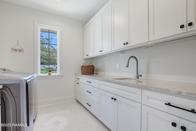 1022 Roselawn Dr, Lafayette, LA 70503 - laundry area featuring a sink, baseboards, cabinet space, and washing machine and clothes dryer