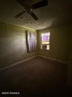 carpeted empty room featuring baseboards and a ceiling fan