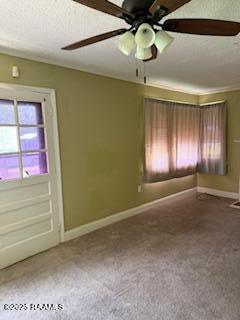 carpeted spare room with baseboards and a ceiling fan