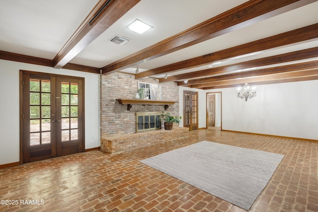 201 W Eleanor St, Opelousas, LA 70570 - unfurnished living room featuring french doors, brick flooring, beam ceiling, a chandelier, and a brick fireplace