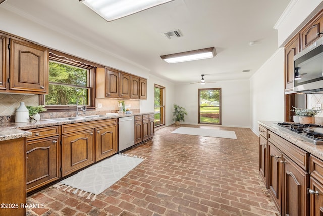 201 W Eleanor St, Opelousas, LA 70570 - kitchen featuring stainless steel appliances, brick floors, backsplash, a ceiling fan, and ornamental molding