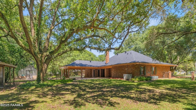 201 W Eleanor St, Opelousas, LA 70570 - back of house featuring an outdoor structure, a greenhouse, brick siding, and a chimney