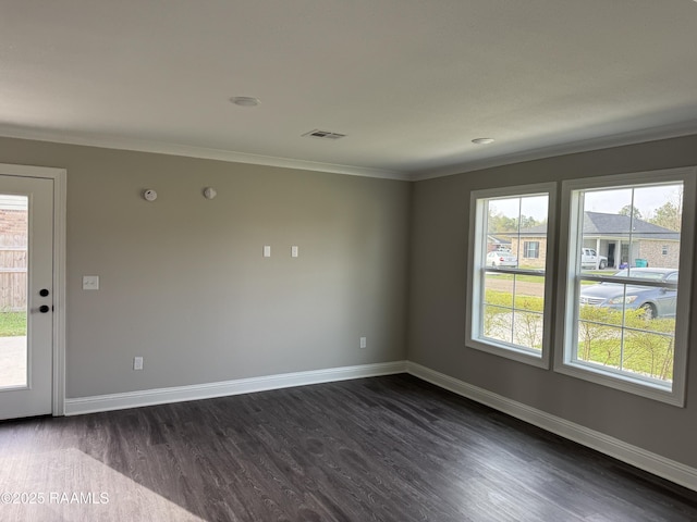 empty room featuring crown molding, baseboards, visible vents, and dark wood-style floors
